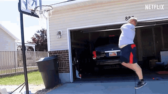 a man is jumping in the air in front of a basketball hoop that says netflix on it