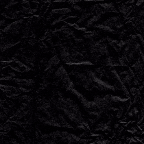 a crumpled piece of black paper with a purple flower in the middle