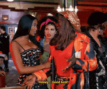 a man in a red jacket is talking to a woman in a corset and says honey good luck .