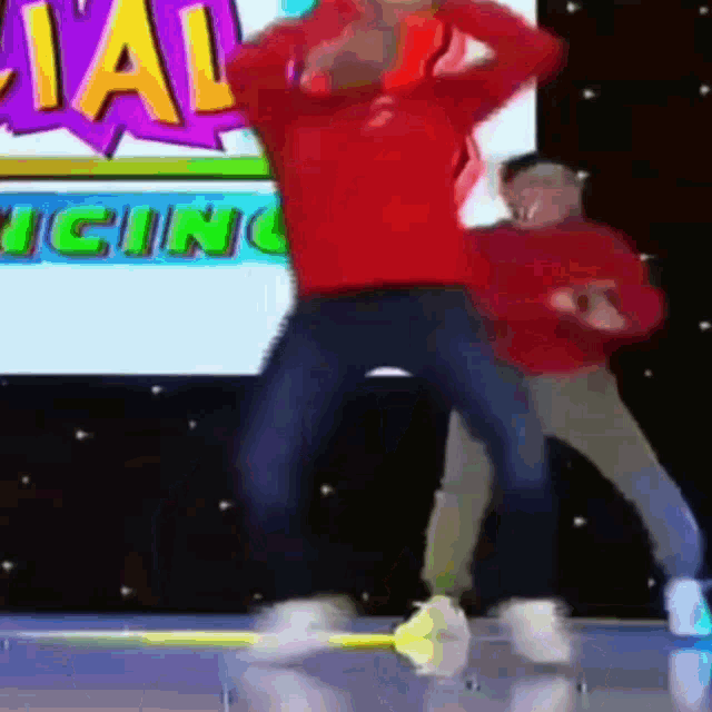 a man in a red sweater is dancing in front of a sign that says ' special icing '