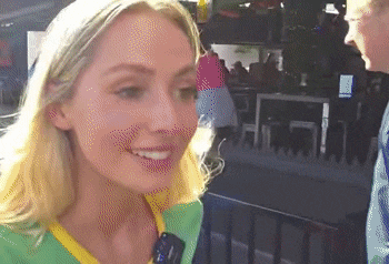 a woman in a yellow and green shirt smiles while talking to a man