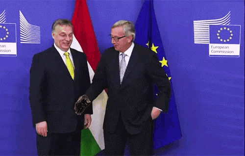 two men are standing in front of flags and a sign that says european commission