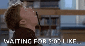 a man is sitting in a library waiting for 5:00 like .