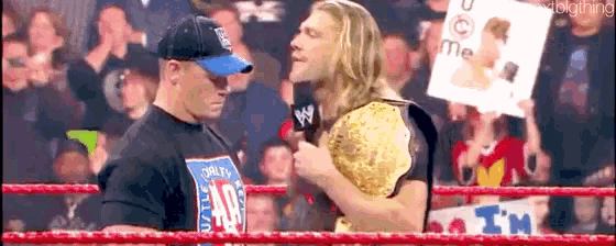 a man in a wrestling ring is holding a sign that says i 'm