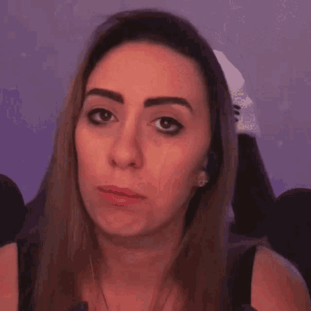 a woman is making a funny face with her hands and fingers .