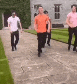 a group of young men are walking down a stone walkway .