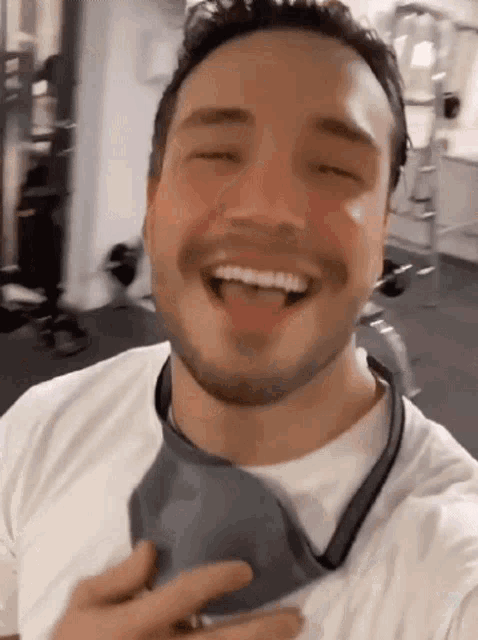 a man with a beard is wearing a face mask and laughing .