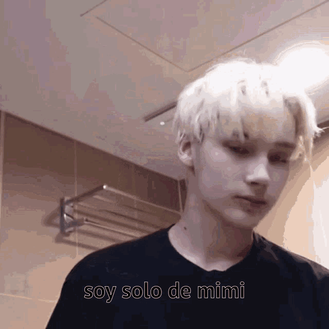 a young man with blonde hair is wearing a black shirt that says soy solo de mimi on it