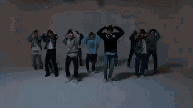 a group of young men are dancing in a foggy room in a video .