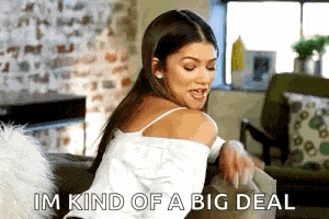 a woman is sitting on a couch in a living room holding a book and saying `` im kind of a big deal ''