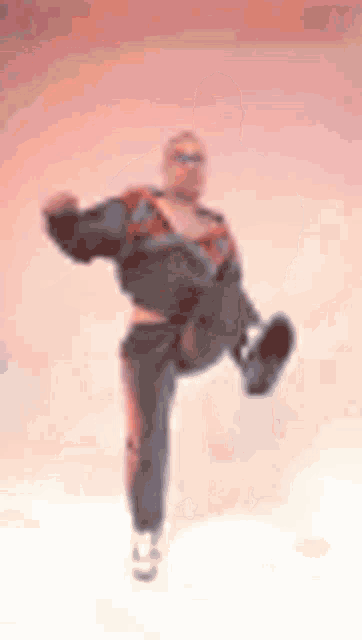 a blurry picture of a man in a tracksuit kicking his leg in the air .