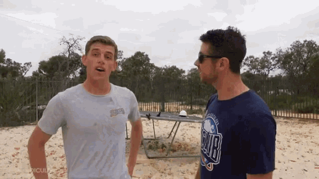 a man wearing a t-shirt that says cubs stands next to another man