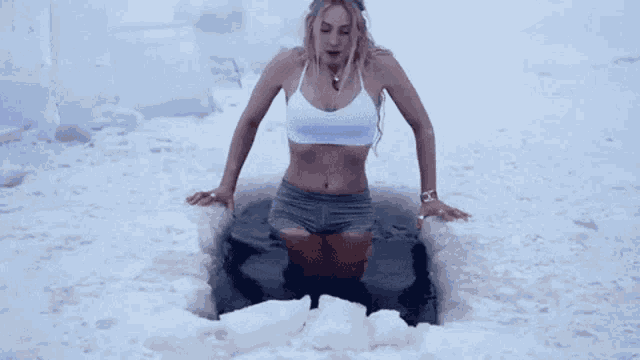 a woman is kneeling in a hole in the snow