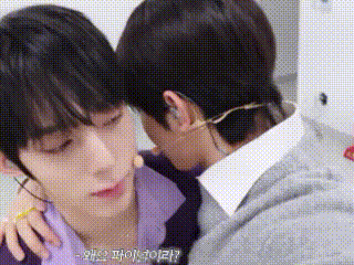 two young men are hugging each other and one of them is wearing a mask .