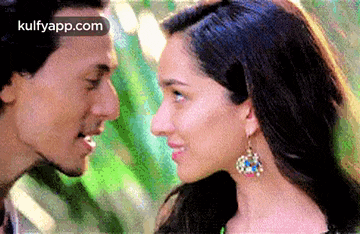 a man and a woman are looking at each other with their eyes closed .