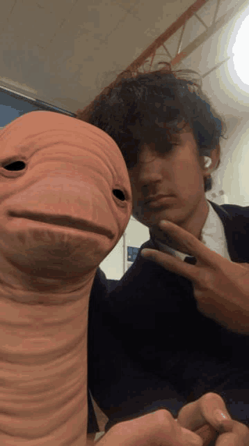 a man with a worm on his head poses for a photo