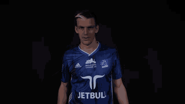 a man wearing a blue shirt with the word jetbul on the front