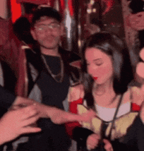 a group of people are standing in a room and one of them is holding another person 's hand .