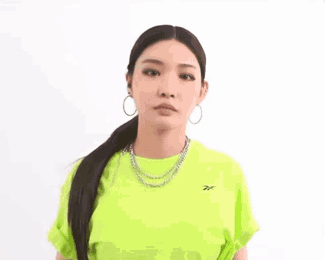 a woman wearing a neon green t-shirt and hoop earrings .