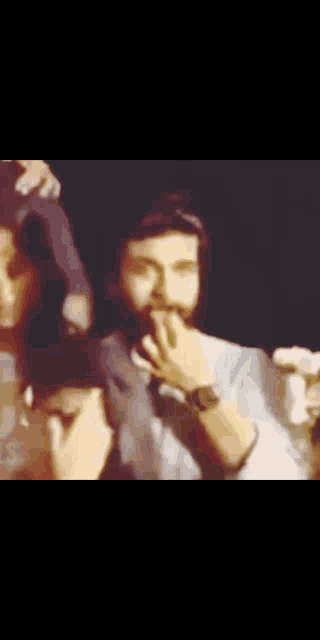a blurry photo of a man with a beard covering his mouth