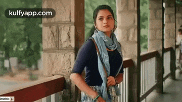 a woman is standing on a balcony looking at something .