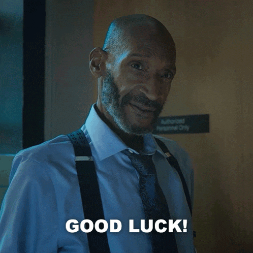 a man with suspenders and a beard is smiling and says good luck