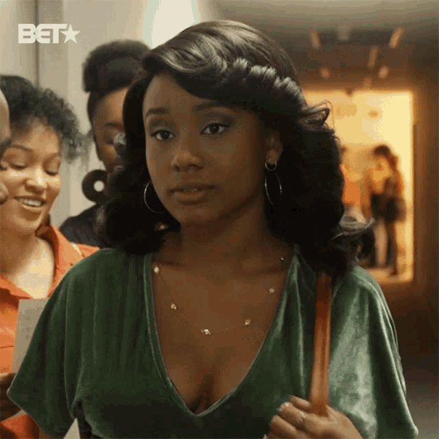 a woman in a green top is standing in a hallway with a bet star behind her