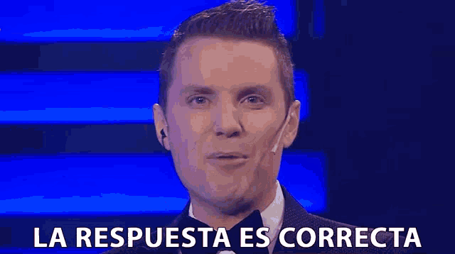a man in a suit and tie is smiling and says la respuesta es correcta in spanish .