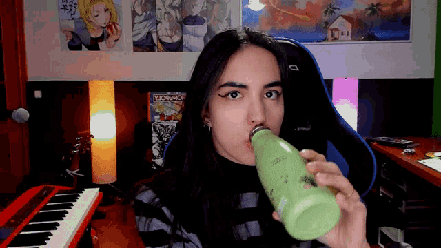 a woman drinking from a green bottle that says ' stainless ' on it