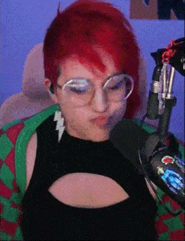 a woman with red hair is sitting in front of a microphone .