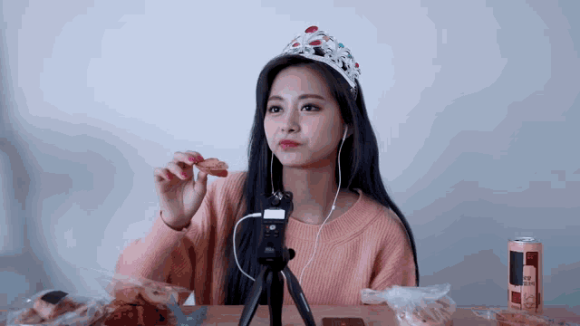 a woman wearing a tiara and headphones is eating bread