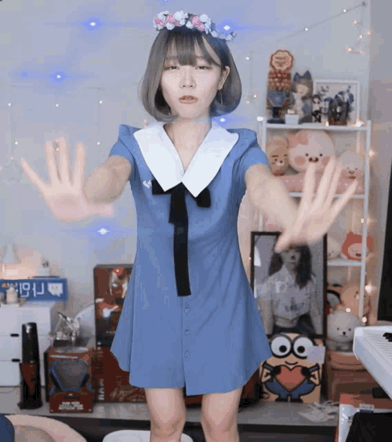 a girl in a blue dress is standing in front of a sign that says ' nbk ' on it