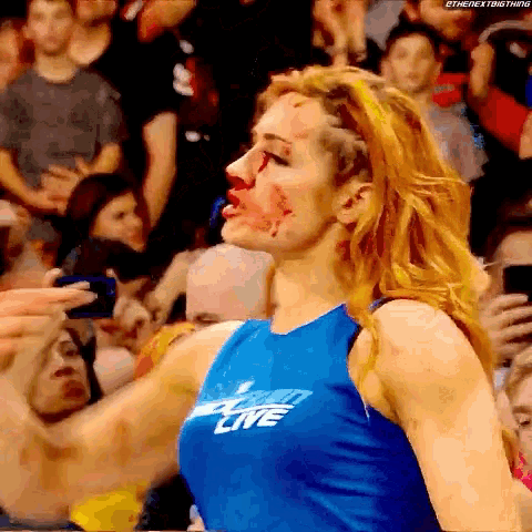 a woman with blood on her face is wearing a shirt that says wrestling live