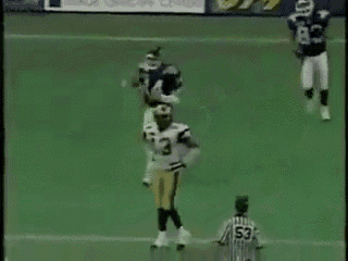 a referee with the number 53 on his jersey is standing on a football field