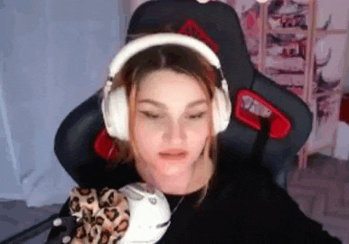 a woman wearing headphones and holding a stuffed animal is sitting in a chair .