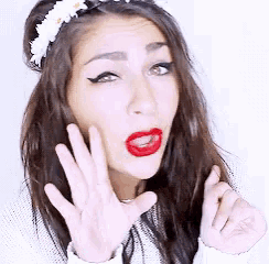 a woman with red lipstick and a flower headband on her head