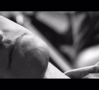 a black and white photo of a person 's face with a finger on it .