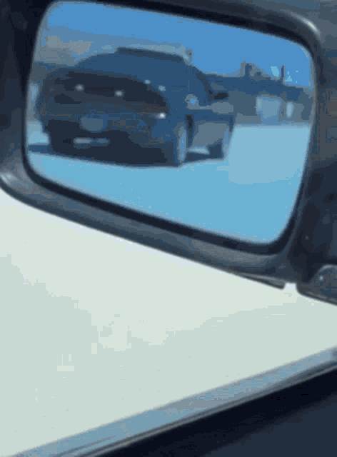 a car is reflected in the rear view mirror of a vehicle
