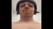 a man without a shirt is wearing a beanie and making a face .