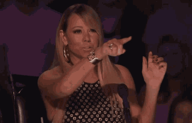 a woman with a ring on her finger is waving her hand