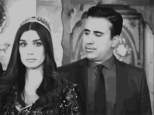 a black and white photo of a man and a woman standing next to each other .