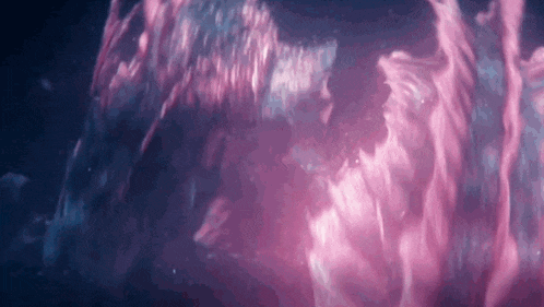 a close up of a purple and blue liquid in a dark room