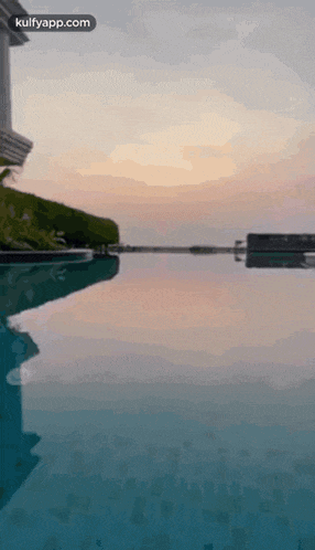 a large swimming pool with a sunset in the background .