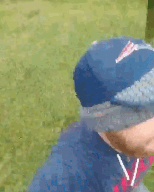 a close up of a person wearing a baseball cap and a hoodie
