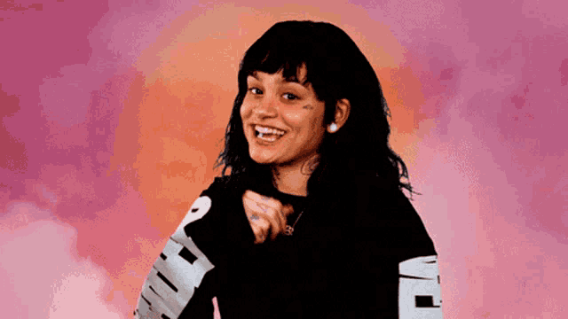 a woman wearing a black puma sweatshirt smiles for the camera