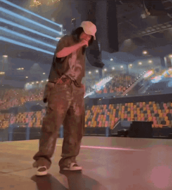 a man wearing a white hat is singing into a microphone