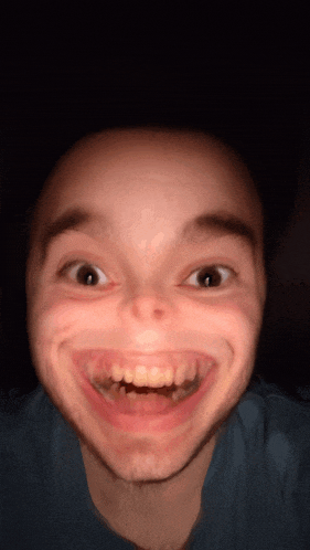 a close up of a man 's face with a big smile