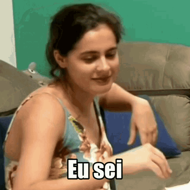 a woman sitting on a couch with the words eu sei on her chest