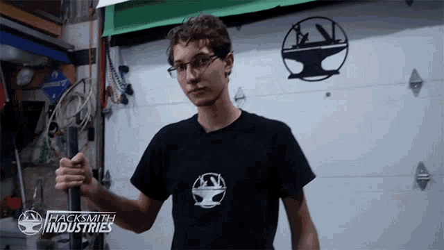 a man wearing a black shirt that says " hacksmith industries " on it