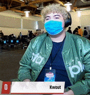a man wearing a mask and a green jacket with the name kwout written on it